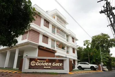 a building with a sign for a golden gate inn at Neom's Golden Gate in Alwaye