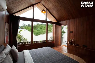 a bedroom with a bed and a large window at StayVista at Reflection by The Woods - Breakfast Included - Luxury Villa in Madikeri