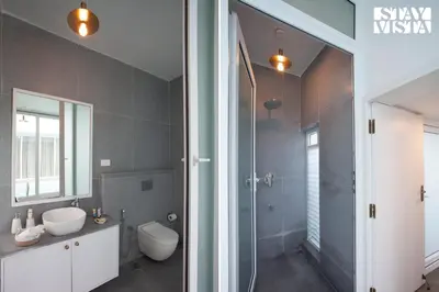 a bathroom with a shower and a toilet and a sink at StayVista at Reflection by The Woods - Breakfast Included - Luxury Villa in Madikeri