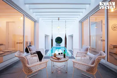 a living room with white chairs and a table at StayVista at Reflection by The Woods - Breakfast Included - Luxury Villa in Madikeri