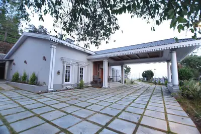 a white house with a patio at Cataleya in Kotagiri