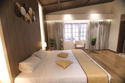a bedroom with a large white bed with two pillows at CATALEYA Home Stay in Kotagiri