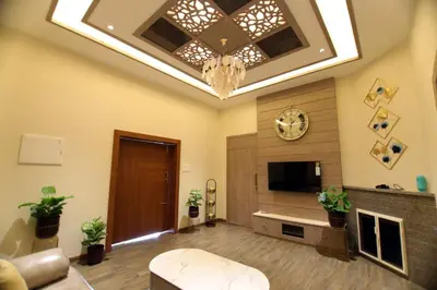 a living room with a tv and a ceiling at CATALEYA Home Stay in Kotagiri