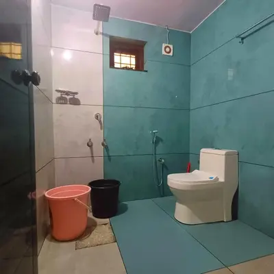 a bathroom with a toilet and a shower at Wayanad Empire Budget Villa in Kalpetta