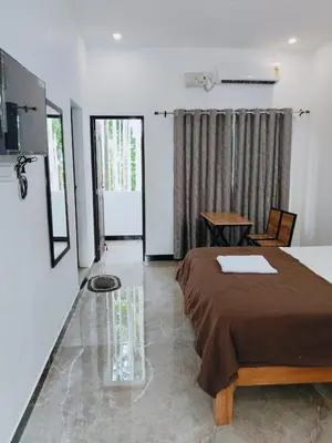 a bedroom with a bed and a table in it at Dream Nest Resort in Mettuppālaiyam