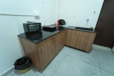 a kitchen with a microwave and a television on a counter at Nandan Enclave in Mysore