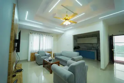 a living room with couches and a ceiling fan at Nandan Enclave in Mysore