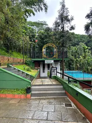 a resort with a swimming pool and a playground at Lush Hills by Benchmark in Kalpetta