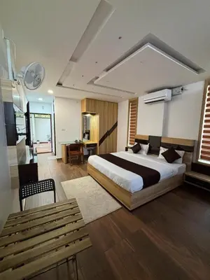 a bedroom with a bed and a table and a bench at Lush Hills by Benchmark in Kalpetta