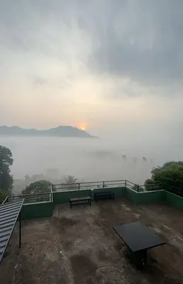a balcony with benches and a view of the water at Lush Hills by Benchmark in Kalpetta