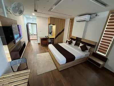 a bedroom with a large bed and a television at Lush Hills by Benchmark in Kalpetta