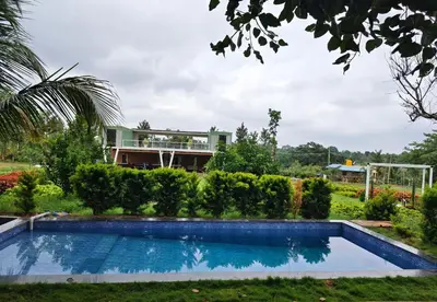 a swimming pool in front of a house at Aadvik Luxury Farmstay in Antarasante