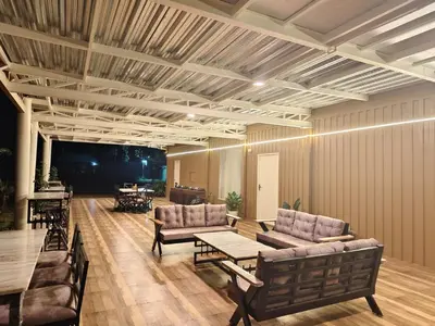 a living room with couches and a table and chairs at Aadvik Luxury Farmstay in Antarasante