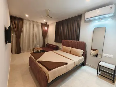 a bedroom with a bed and a living room at Aadvik Luxury Farmstay in Antarasante