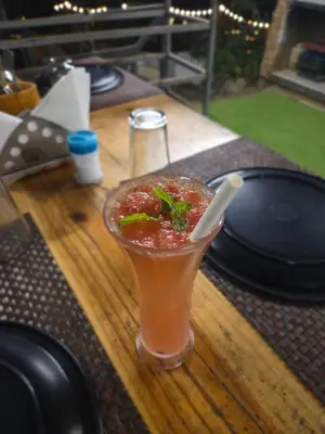 a drink sitting on top of a wooden table at Forestscape Resort Munnar in Munnar