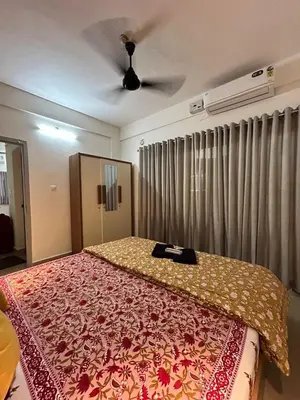 a bedroom with a bed with a red and yellow blanket at 1 BHK Fully Furnished - Soorya Madhavam Apartments - Flat No - C2 - Guruvayur, - 150m to North Nada - Family only in Guruvāyūr