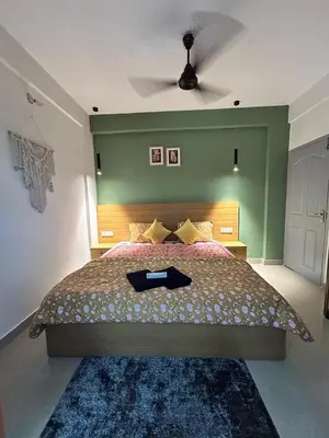 a bedroom with a large bed with a ceiling fan at 1 BHK Fully Furnished - Soorya Madhavam Apartments - Flat No - C2 - Guruvayur, - 150m to North Nada - Family only in Guruvāyūr