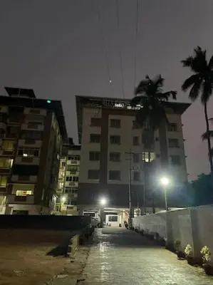 a building with palm trees and a street at night at 1 BHK Fully Furnished - Soorya Madhavam Apartments - Flat No - C2 - Guruvayur, - 150m to North Nada - Family only in Guruvāyūr