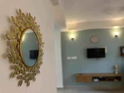 a mirror is hanging on a wall in a room at 1 BHK Fully Furnished - Soorya Madhavam Apartments - Flat No - C2 - Guruvayur, - 150m to North Nada - Family only in Guruvāyūr