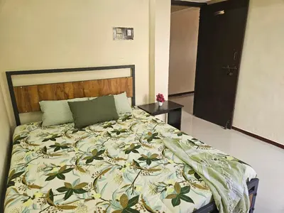 a bedroom with a large bed with a blanket on it at SHI's Ganga 2BHK in GN Mills, Ganga Hospital, Women's Care Coimbatore in Coimbatore