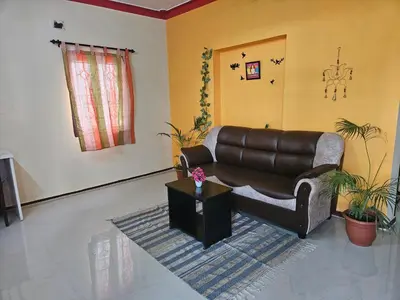 a living room with a leather couch and a table at SHI's Ganga 2BHK in GN Mills, Ganga Hospital, Women's Care Coimbatore in Coimbatore