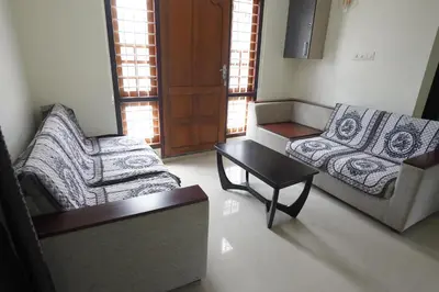 a living room with two couches and a coffee table at Swapna Home Suites in Nedumbassery
