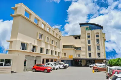 a building with cars parked in a parking lot at mesta Hotel in Sultan Bathery