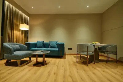 a living room with a blue couch and chairs at mesta Hotel in Sultan Bathery