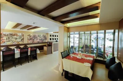a restaurant with a dining room with tables and chairs at Sreepathi Indraprastha in Guruvāyūr