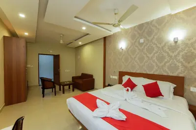 a bedroom with a large bed with red and white pillows at Sreepathi Indraprastha in Guruvāyūr