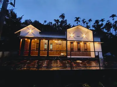 a small house with lights on in the night at Dream Nest Villa Wayanad in Kalpetta