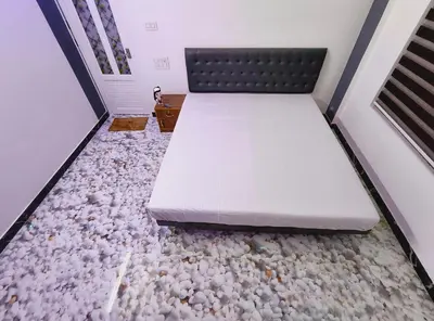 a bed in a room with rocks on the floor at Dream Nest Villa Wayanad in Kalpetta