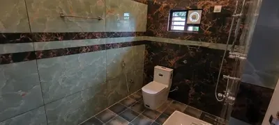 a bathroom with a toilet and a glass shower at Dream Nest Villa Wayanad in Kalpetta