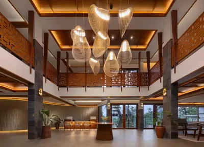 a lobby with tables and chairs and a chandelier at Sterling Lontano Waterfront Wayanad in Meppādi