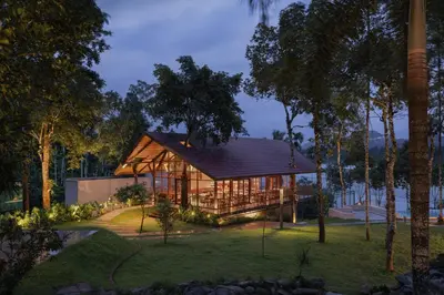 a wooden house with a glass facade at Sterling Lontano Waterfront Wayanad in Meppādi