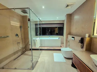 a bathroom with a shower and a toilet and a tub at Sterling Lontano Waterfront Wayanad in Meppādi