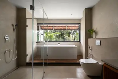 a bathroom with a tub and a toilet and a window at Sterling Lontano Waterfront Wayanad in Meppādi