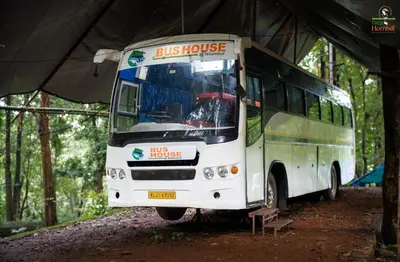 a bus parked under a tent in the woods at Great Hornbill Serviced Villa , Nilambur in Kālikāvu
