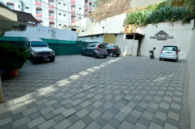 a parking lot with cars parked next to a building at BN Tourist Home in Ooty