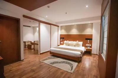 a large bedroom with a bed and a desk at Hotel Niya Regency in Trichūr