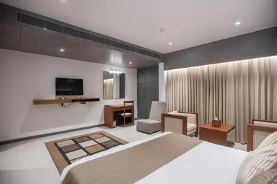 a bedroom with a bed and a desk and a television at Hotel Niya Regency in Trichūr