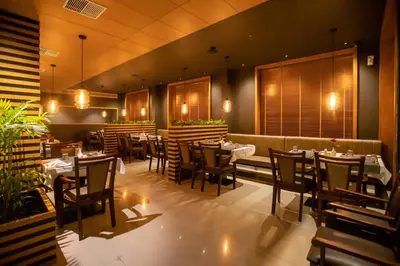 a restaurant with tables and chairs in a room at Hotel Niya Regency in Trichūr