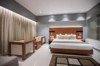 a hotel room with a bed and a desk at Hotel Niya Regency in Trichūr