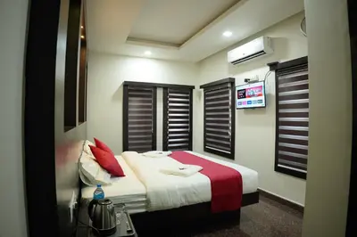 a bedroom with a bed with red pillows at Hill Club Square in Malappuram