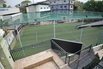 an empty tennis court with a soccer field at Hill Club Square in Malappuram