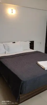 a large bed in a white room with at VVP Service Apartments & Airport Suits in Cochin