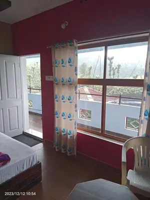 a bedroom with a bed and a large window at RIVERVIEW HOMESTAy in Vālpārai