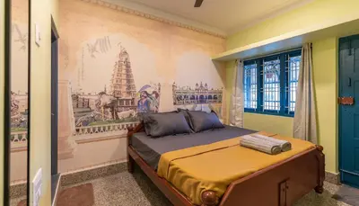 a bedroom with a bed with a painting on the wall at Trippr Mysuru in Mysore