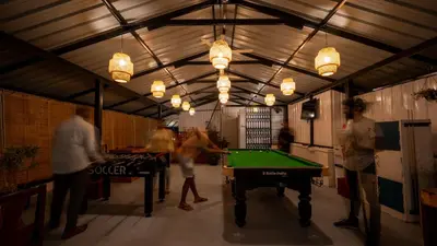 a group of people playing pool in a garage at Trippr Mysuru in Mysore