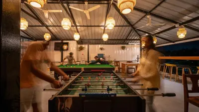a group of people standing around a pool table at Trippr Mysuru in Mysore